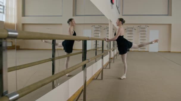 Балерина Тренировочном Костюме Стоит Перед Балетным Баром Танцевальной Студии Разминает — стоковое видео