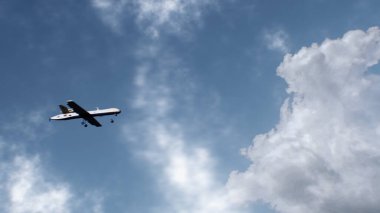 3D animation of military drone flight. Combat drone on military mission. Cloudy sky on background. Remotely-piloted aircraft. Concept of using modern UAV technology for military battles or in war.