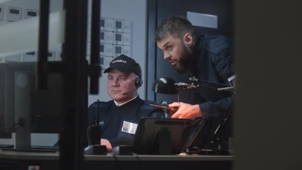 Dva Bezpečnostní Důstojníci Dívají Bezpečnostních Kamer Monitoru Počítače Muž Mluví — Stock video