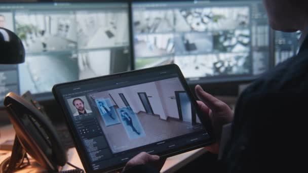 セキュリティオペレータは オフィスでCctvカメラを制御します 画面上の監視カメラの映像とデジタルタブレットやコンピュータを使用しています 顔認識を備えたハイテクセキュリティシステム 社会的安全 — ストック動画