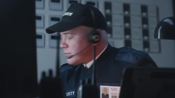 Αξιωματικός Ασφαλείας Στα Ακουστικά Κάθεται Δίπλα Στο Τραπέζι Φαίνεται Θέα — Αρχείο Βίντεο