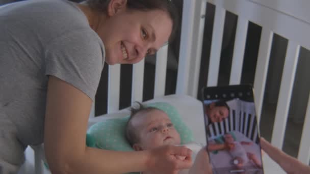 Отец Фотографирует Счастливую Мать Новорожденной Красивой Дочерью Сыном Используя Смартфон — стоковое видео