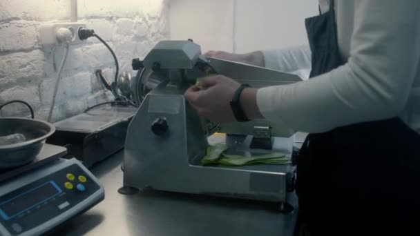 男厨师为菜肴准备配料 人在厨房工作 用电动蔬菜切菜刀切西葫芦 烹调的过程 餐厅提供专业的美味佳肴 公共饮食 — 图库视频影像