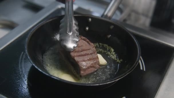 El chef profesional pone sal al horno en rodajas de ternera en la tabla de  cortar de la cocina