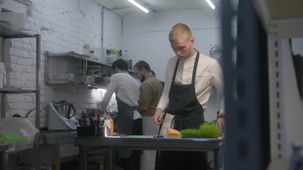 Önlüklü Erkek Aşçı Mutfak Masasının Yanında Duruyor Tatlı Patates Kesiyor — Stok video