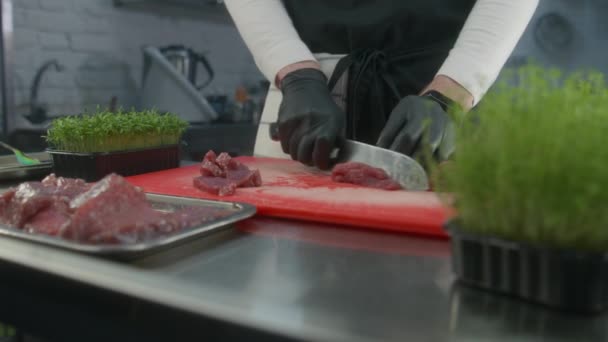 专业厨师在围裙切割切块切块切块在切块板上 一盒箱箱的微绿色放在厨房的桌子上 厨师的手部特写 有专业烹调的餐厅 公共饮食 — 图库视频影像