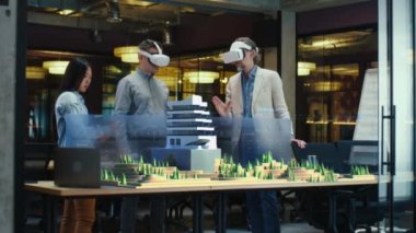 Erkek mimar sanal gerçeklikteki modern yüksek teknoloji binasını ve park mimari projesini meslektaşlarına sunar. Üç boyutlu hologram. Gelecekteki dijital yapay zeka teknolojileri.