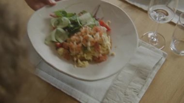Garsonun konuğumuza lezzetli tabaklar getirdiği yakın çekim. Çırpılmış tost, karides, sos ve yeşil salata modern mutfağın olduğu restoranda masada duruyor. Toplu yemek kavramı.