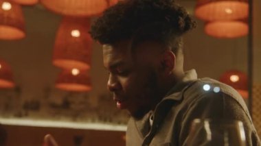 Afrikalı Amerikalı adam modern kafede oturuyor ve konuşuyor. Arkadaşlarıyla buluşan ya da gastro barında randevusu olan bir adam geceyi dışarıda geçirir. Aile yemeği, restoranda doğum günü partisi. Kamu hizmeti konsepti.