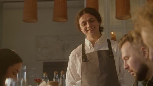 Man Ober Glimlacht Serveert Een Groep Vrienden Cafe Gasten Kijken — Stockvideo