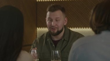 Kafkasyalı bir adam modern gastro kafede oturur, lezzetli yemekler yer ve arkadaşlarıyla konuşur. Bir grup insan doğum gününü kutlar, aile yemeği yer, hafta sonunu birlikte restoranda geçirirler. Toplu yemek kavramı.