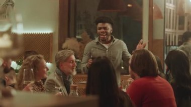 Afro-Amerikalı adam tost diyor. Bir grup arkadaş bardakları tokuşturur ve modern gastro kafede şarap içerler. İnsanlar geceyi birlikte geçirir, restoranda doğum günü partisinde takılırlar. Kamu hizmeti konsepti.