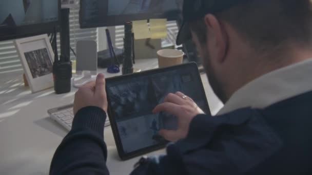 警卫用数字平板电脑监控办公室里的闭路电视摄像头 显示屏幕上有扫描系统的监控摄像头的程序 高科技安全 社会安全的概念 — 图库视频影像