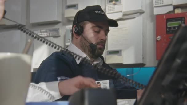 Security Officer Headset Sits Workplace Types Keyboard Looks Computer Monitors — Stock Video