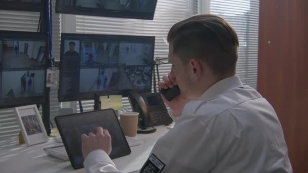 安保人员监控电脑和数字平板电脑上的闭路电视摄像头 使用对讲机 在屏幕上显示监控摄像头视频的软件 高科技安全 社会安全的概念 — 图库视频影像