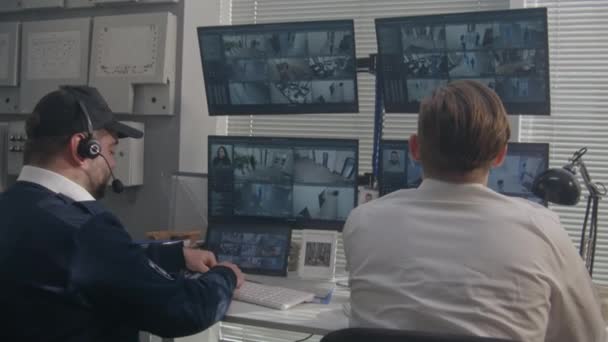 Biztonsági Tisztek Ülnek Megfigyelő Szobában Figyelik Cctv Kamerákat Szkenner Rendszerrel — Stock videók