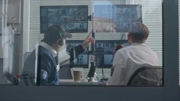 安全官员坐在监视室 用人工智能扫描系统用现代软件在电脑屏幕上监视闭路电视摄像机 保安用收音机 观察和安全的概念 — 图库视频影像