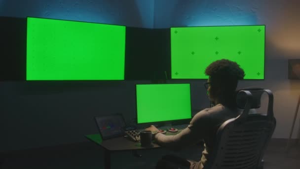 非裔美国人在工作室的电脑上工作 带着设备 多色键大屏幕在墙上 平板电脑上显示的专业软件 分色或电影编辑室 Dolly Shot — 图库视频影像