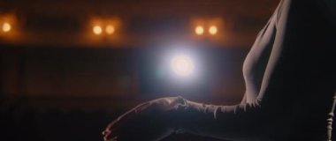 Balerinin tiyatro sahnesindeki partneriyle performansı tartışmasını yakından çek. Kadın balerin jestleri ve provada koreografi hakkında konuşmalar. Aydınlatılmış tiyatro salonu. Klasik bale.