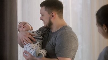 Çocuk odasında gündüz uykusuna yatmadan önce bebek tulumuyla yatışır. Şefkatli bir baba, tatlı kızını ya da oğlunu kollarına alır, gülümser ve karısıyla konuşur. Çocukluk kavramı, ebeveynlik, aile ve aşk.