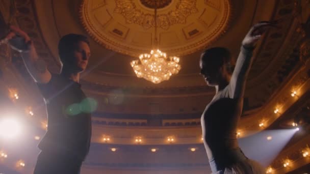 バレエダンサーのカップルは 舞台上で振付を練習し 一緒に演奏する準備をします ショーリハーサルでトレーニングスーツのパートナーとバレリーナ 古典バレエ芸術の概念 — ストック動画