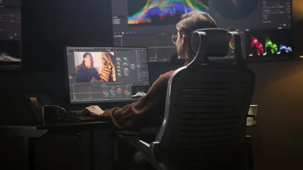 女编辑使用专业编辑软件在现代计算机演播室工作 女性编辑视频镜头 为电影后期制作配色 墙上有Rgb图形的大屏幕 — 图库照片
