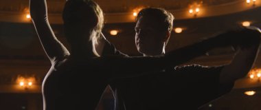 Sahne ışıklarıyla aydınlatılmış klasik tiyatro sahnesinde bale dansçılarının koreografi çalışmalarını ve provalarını yakından çek. Partnerler tiyatro dans gösterisi için hazırlanır. Klasik bale dansı..