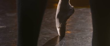 Bale dansçılarının geniş açılı fotoğraflarını çek. Sivri uçlu ayakkabılı balerin parmak uçlarında dans eder ve döner. Sahnedeki koreografi provası spot ışıklarıyla aydınlatıldı. Klasik bale gösterisi.