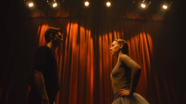 Perdeler açık, bale dansçıları sahne ışıklarıyla aydınlatılmış klasik tiyatro sahnesinde dans ediyorlar. Dans partnerleri koreografi provasında tiyatro balesi gösterisi için alıştırma yapıyorlar..