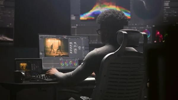 在现代演播室里 非裔美国人电影编辑在电脑上做色彩分级 大监视器与Rgb色彩校正图形条和程序接口在墙上 视频张贴制作 — 图库照片
