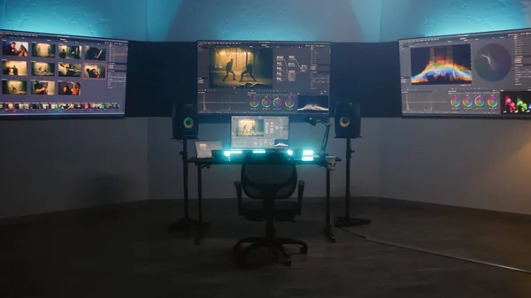 Studio with modern equipment for color correction. Computer, digital tablet and big screens showing color grading program interface with movie footage, RGB graphics and color wheels. Post production.