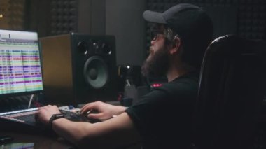 Deneyimli ses mühendisi ses kayıt stüdyosunda yeni şarkı sesleri yaratmak için karıştırma tahtası kullanır. Bilgisayar ekranında program ve araçlar. Dijital ses istasyonu yazılımı. Müzik üretimi kavramı.