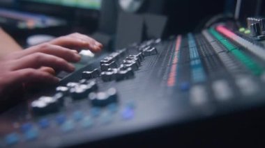 Ses mühendisinin miksaj konsolu, ses ayarlaması için uzaktan kumanda ve ses karıştırıcı kullanarak çekimini kapat. Müzisyen ses seviyesini değiştirir, müzik yaratır. Ses kayıt stüdyosu. Müzik üretimi.