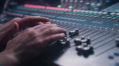 Ses mühendisinin miksaj konsolu, ses ayarlaması için uzaktan kumanda ve ses karıştırıcı kullanarak çekimini kapat. Müzisyen ses seviyesini değiştirir, müzik yaratır. Ses kayıt stüdyosu. Müzik üretimi.
