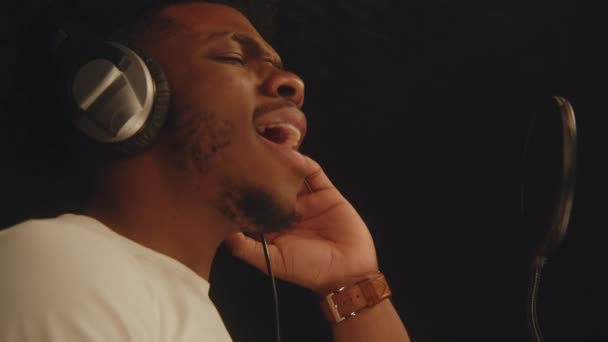 Αφροαμερικανός Τραγουδιστής Χορούς Ακουστικών Τραγουδάει Λυρική Σύνθεση Μικρόφωνο Ηχομονωτικό Δωμάτιο — Αρχείο Βίντεο