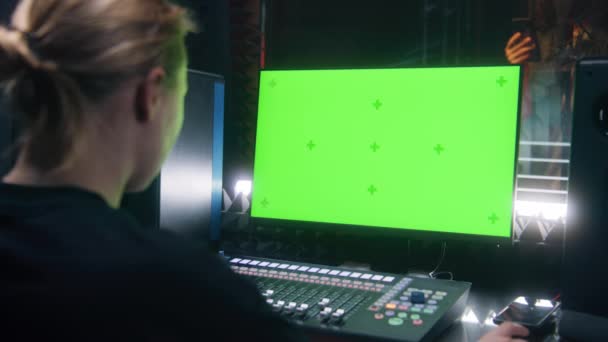 女性オーディオエンジニア プロデューサーはミキシングボードを使用しています Pcモニターの緑の画面 コンピューター画面にはDawソフトウェアのユーザーインターフェイスが表示されます ミュージシャンは防音室で歌を歌う 録音スタジオ — ストック動画