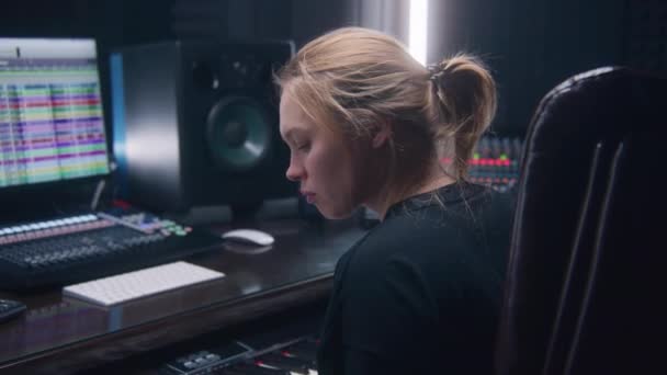 女性オーディオエンジニア ミュージシャンはエレクトリックピアノを演奏し 新しい曲のためのメロディーを記録します サウンドトラックとDawプログラムインターフェースを示すコンピュータ画面 録音スタジオで働く 音楽制作 — ストック動画