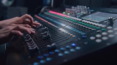 Müzisyen karıştırma konsolu kullanır, sesi ayarlamak için uzaktan kumanda, ses karıştırıcı. Ses mühendisi ses seviyesini değiştirir, modern ekipmanlarla müzik yaratır. Ses kayıt stüdyosu. Müzik üretimi.