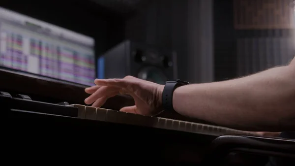 オーディオエンジニア プロデューサーは音楽制作にMidiコントローラー デジタル電気ピアノを使用します サウンドトラックとDawソフトウェアインターフェイスを示す画面 録音スタジオだ 音楽制作 閉じろ — ストック写真