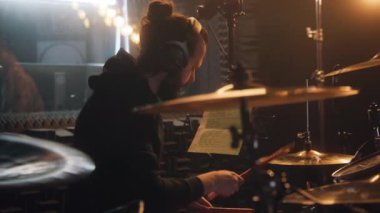 Kulaklıklı bir erkek müzisyen davul çalıyor. Müzikal rock grubu albümü için ses geçirmez müzik odasında davulcu şarkısı. Ses kayıt stüdyosunda çalışıyorum. Müzik üretimi kavramı.