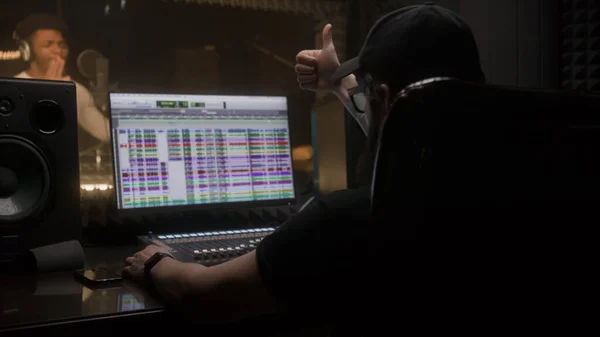 사운드 엔지니어는 가수에게 박수를 보내며 컴퓨터로 디지털 오디오 워크스테이션 소프트웨어로 — 스톡 사진