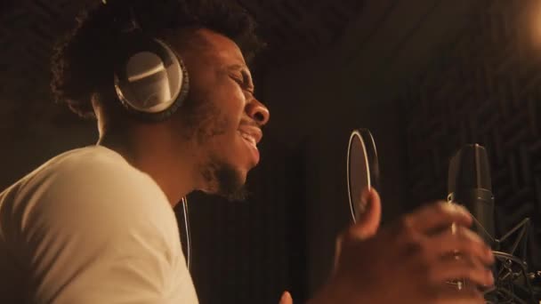 아프리카 미국인 가수가 헤드폰 장치가 방에서 의구성을 마이크로폰 부른다 보컬리스트들은 — 비디오