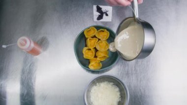 Deneyimli aşçı tabağa ravioli döker ve üzerine peynir serper. Şef yemek sunumu yapıyor. Gastronomi. Profesyonel gurme mutfağı olan bir restoran. Kamu hizmeti. Kapat..