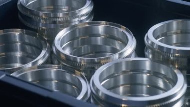 Kesik ve cilalanmış mercek metal işçiliğiyle rafları yakın plan çek. Sinema lensi diyafram ve odaklama üretimini etkiler. Metal fabrikasında çalışıyor. Üretim, sanayi ve teknoloji kavramı.
