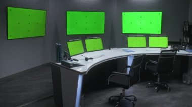 Güvenlik kontrol merkezinde CCTV kameralarını izlemek için çalışma alanı. Masadaki bilgisayar monitörleri ve duvardaki büyük dijital ekranlarda kroma anahtarı güvenlik kamerası görüntülerini gösteriyor. Yeşil Ekran.