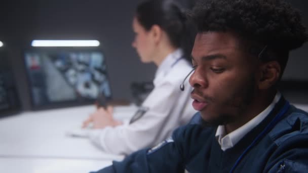 Gözetleme Odasında Kulaklıklı Afro Amerikan Güvenlik Operatörü Arkadaşı Klavye Ile — Stok video