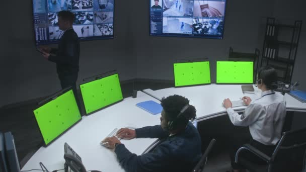 Многорасовые Офицеры Контролируют Камеры Безопасности Рабочие Центре Контроля Больших Цифровых — стоковое видео