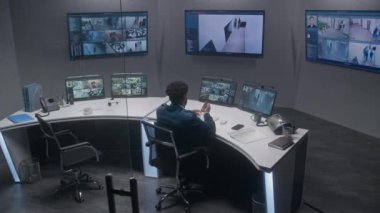 Polis gözlem merkezinde çalışan çok ırklı güvenlik görevlileri. Büyük dijital ekranlar ve güvenlik kameralı bilgisayar monitörleri. Sosyal güvenlik kavramı. Zaman Uygulaması.