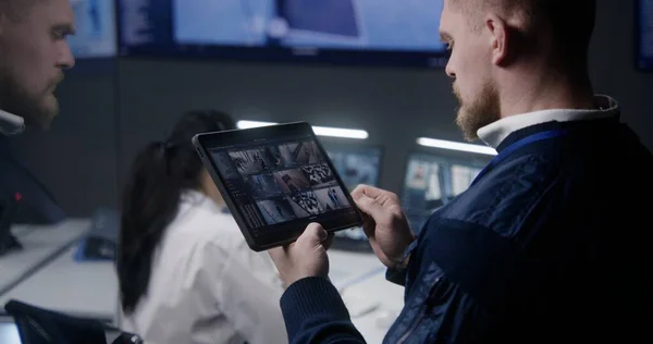 Mężczyzna Przybliża Kontroluje Kamery Używa Tabletu Centrum Monitorowania Policji Operatorzy — Zdjęcie stockowe