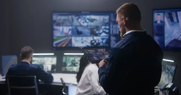 Mannelijke Agent Controleert Beveiligingscamera Politie Bewakingscentrum Gebruikt Tablet Monitoren Meerdere — Stockfoto